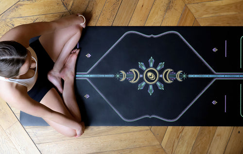 Woman sitting cross-legged on a black Liforme Yoga mat