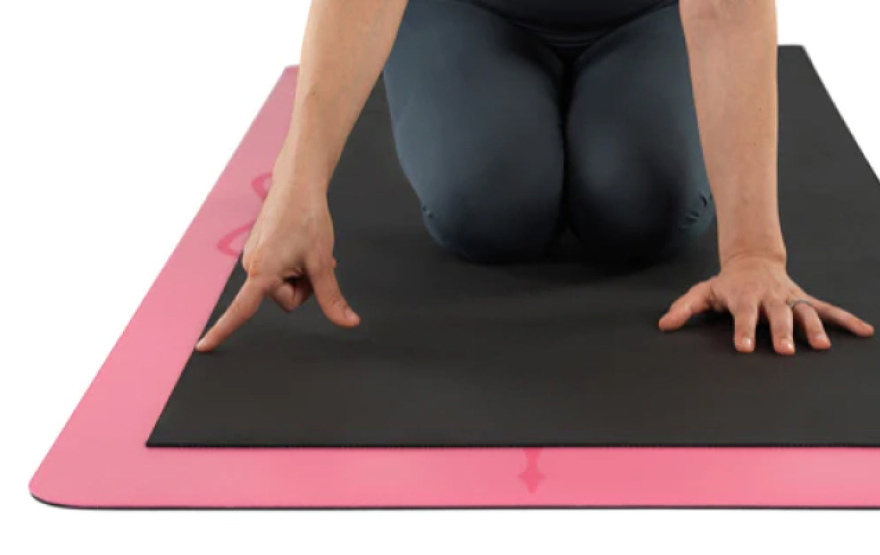 Top-down view showing the extra-large dimensions of the Liforme Pink Classic Yoga Mat, which is longer and wider than standard mats for more practice space.