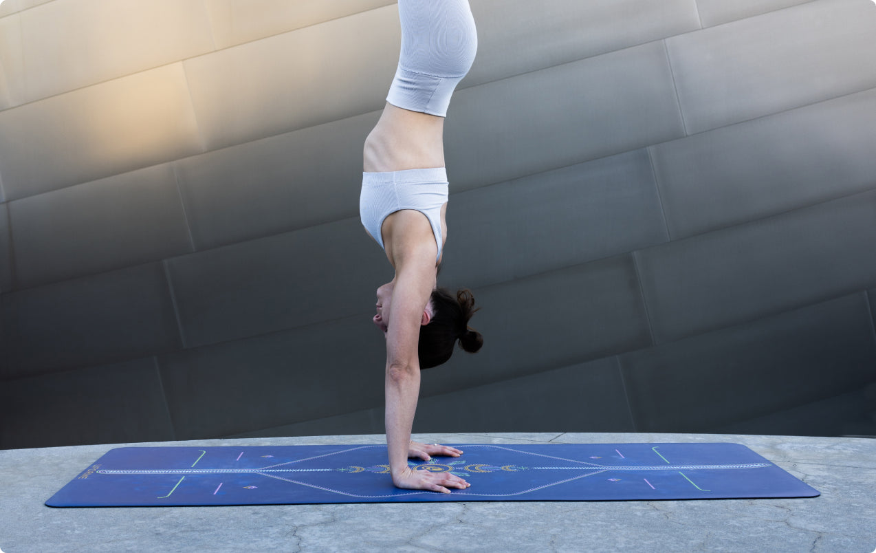 A yogi performing a handstand on the Cosmic Moon mat, demonstrating the superior traction of the GripForMe technology even during sweaty sessions.