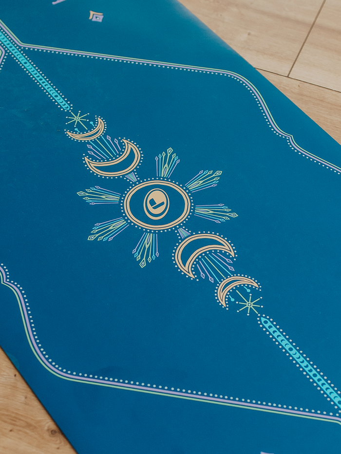 Close up shot of the Liforme Cosmic Moon Yoga Mat showing Liforme's alignmet guide on a wooden floor
