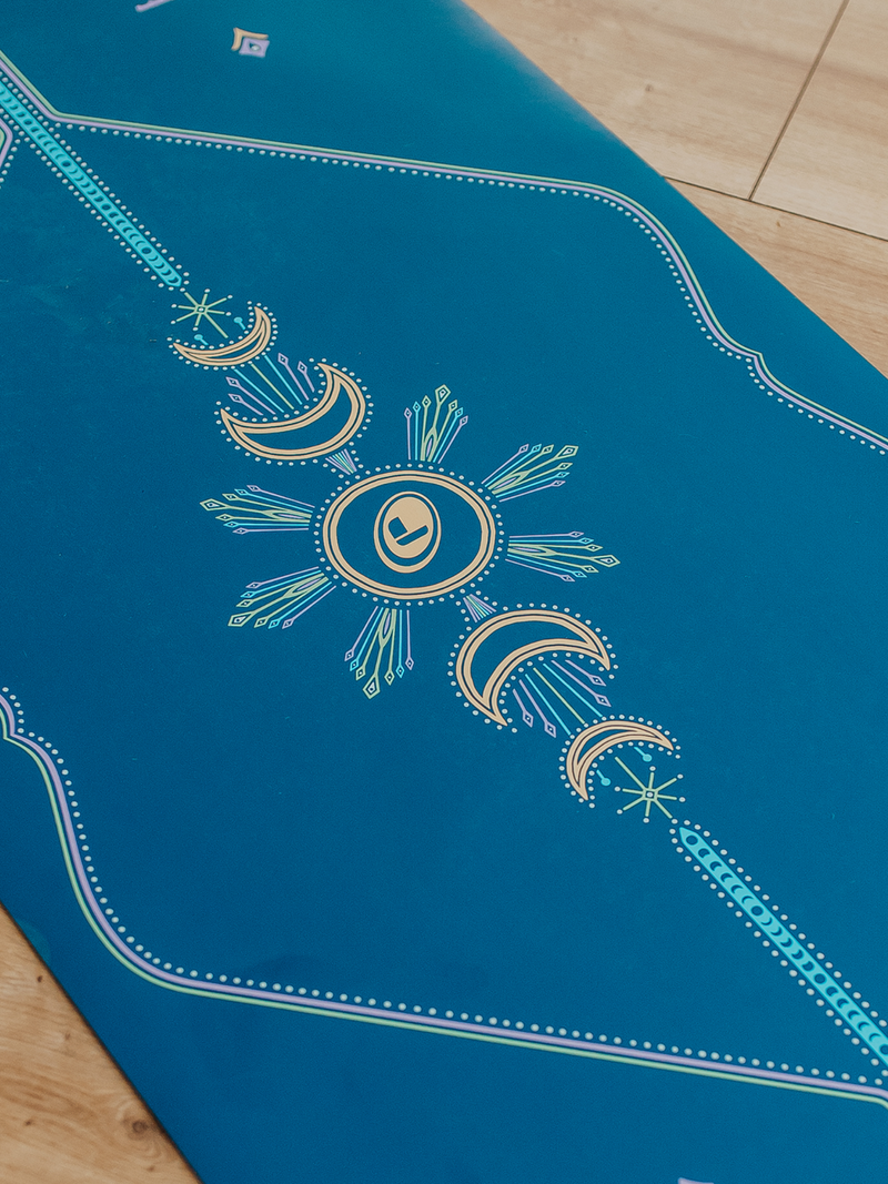 Close up shot of the Liforme Cosmic Moon Yoga Mat showing Liforme's alignmet guide on a wooden floor