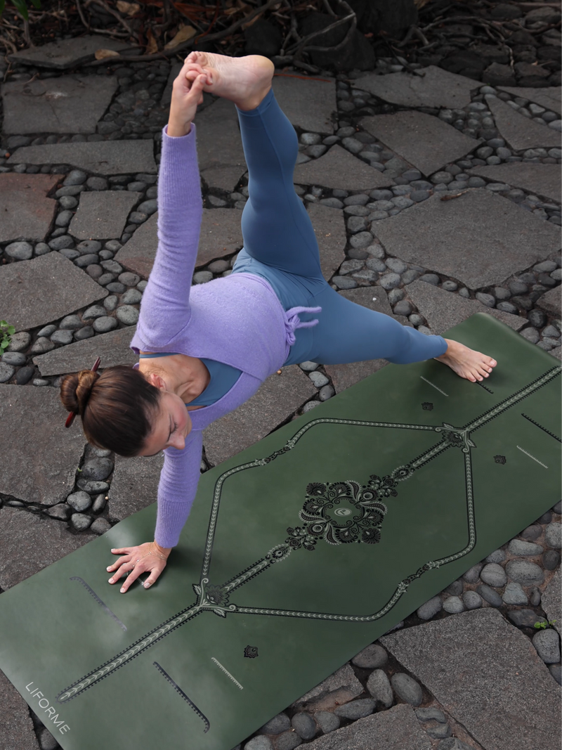 A woman in a side plank yoga pose on a Liforme Deep Forest Mindful Garden Yoga Mat 