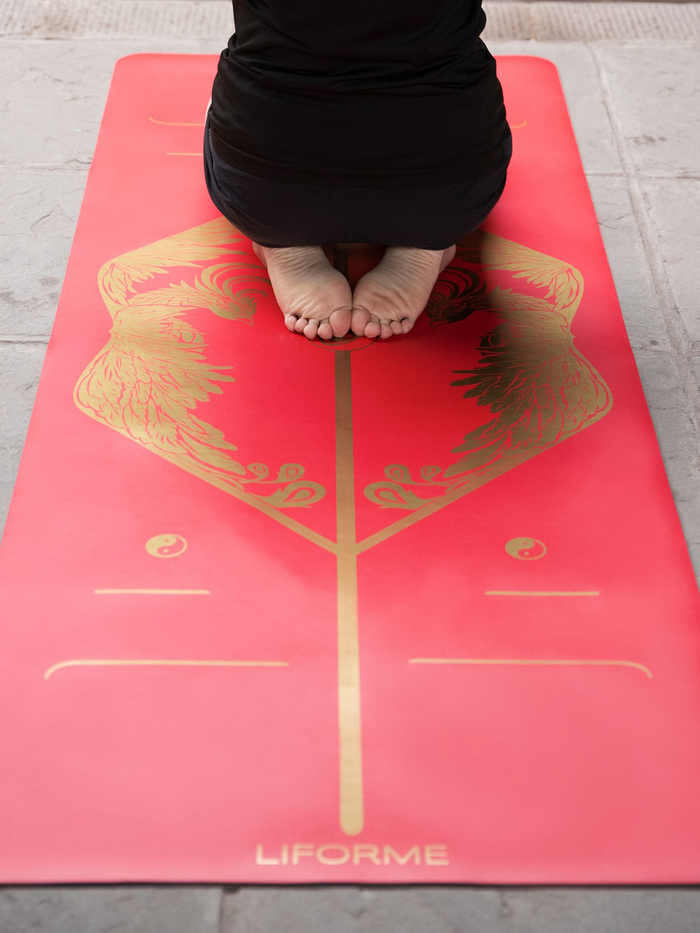 A man practicing yoga on a Liforme Phoenix Yoga Mat 