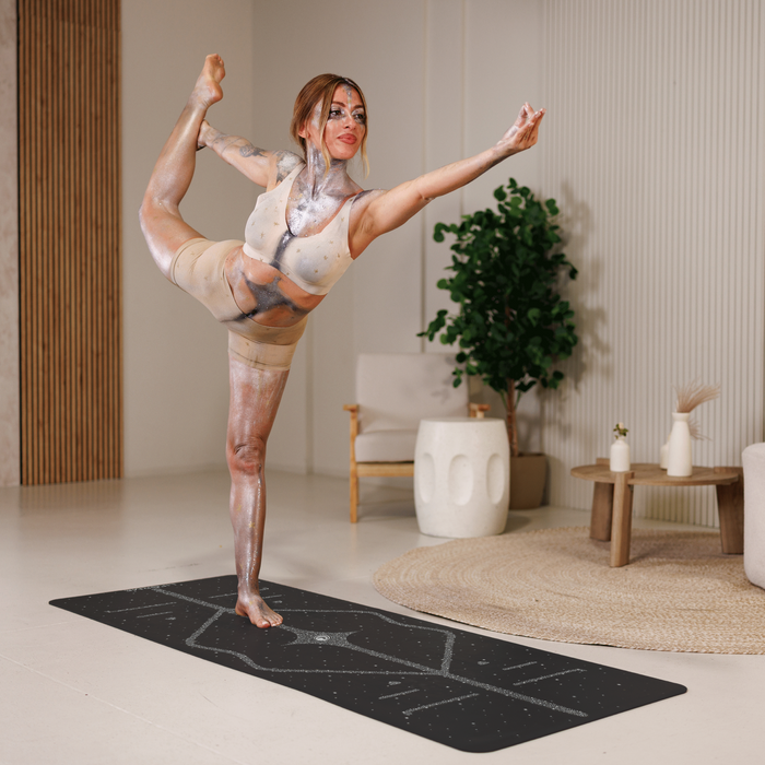 A woman performs a dancer yoga pose on a Liforme Magic Galaxy Yoga Mat Silver Black