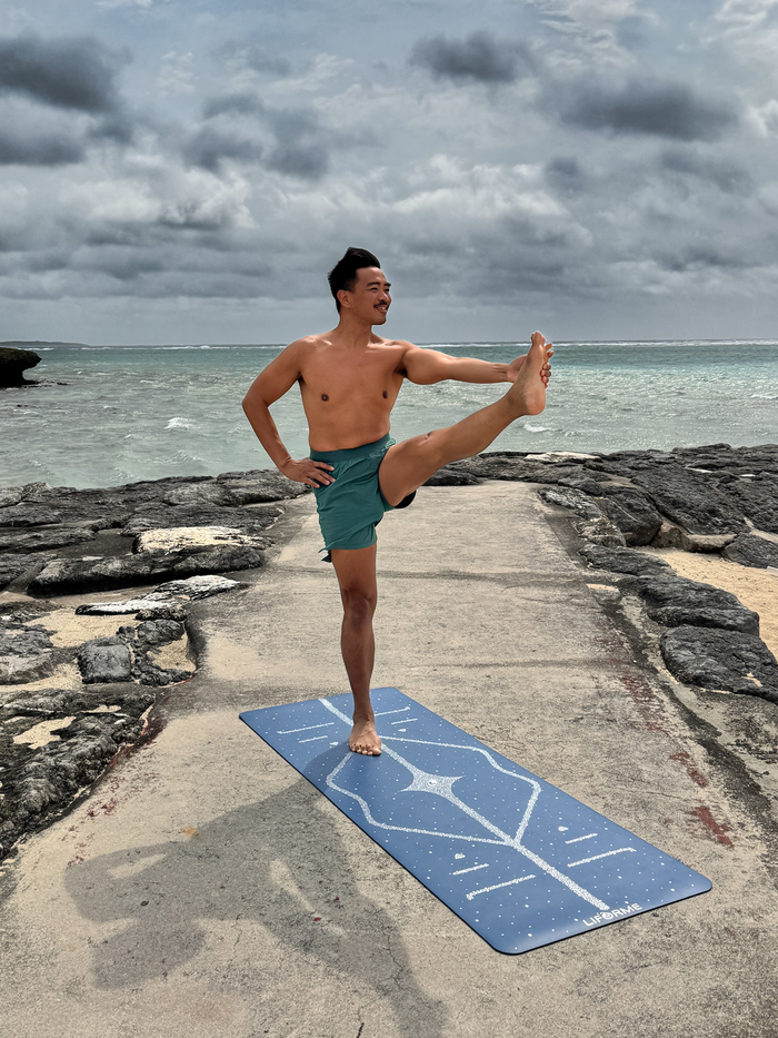A man practicing yoga on a Liforme Magic Galaxy Yoga Mat Silver Dusk Blue 