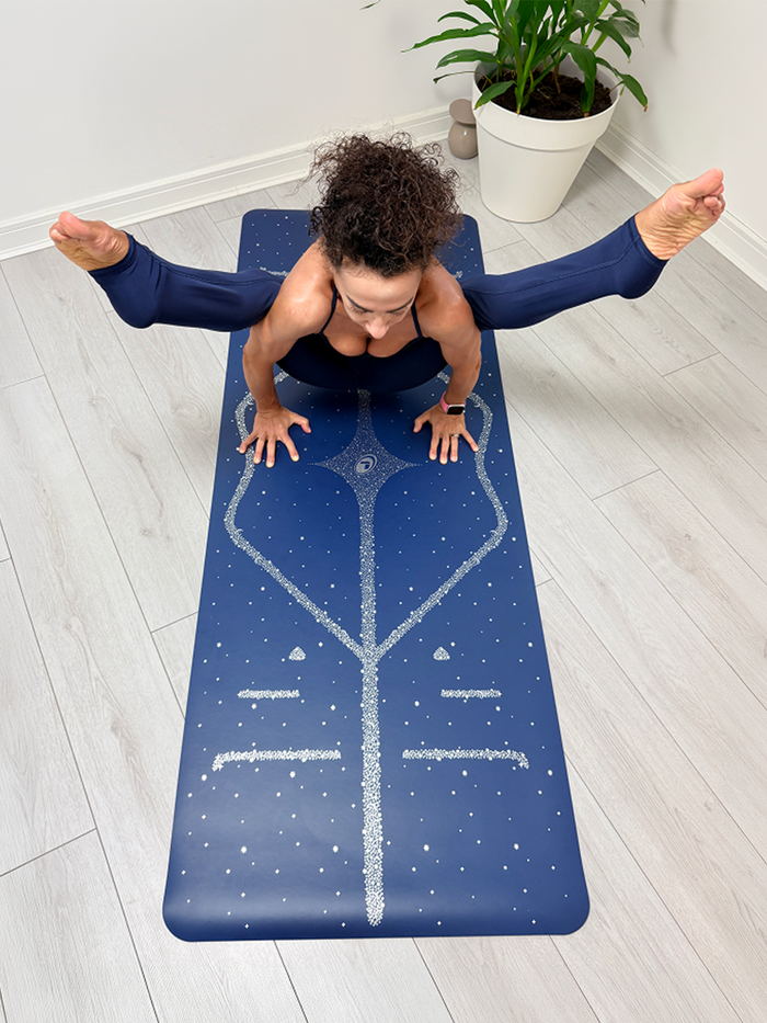 A woman in a yoga pose on a Liforme Magic Galaxy Yoga Mat Silver Dusk Blue 