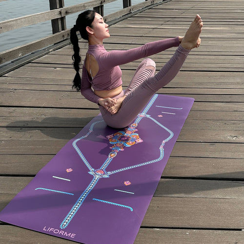 Yogi practicing a Compass Pose variation on a Purple Liforme Mindful Garden Yoga Mat outdoors on a wooden pier to demonstrate advanced balance and grip.