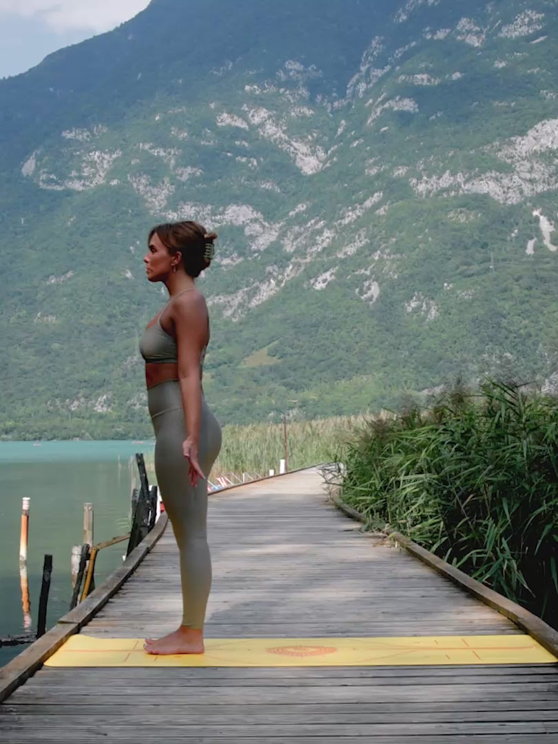 Person practicing yoga on a Liforme Radian Yoga Mat Yellow in a beautiful outdoor setting